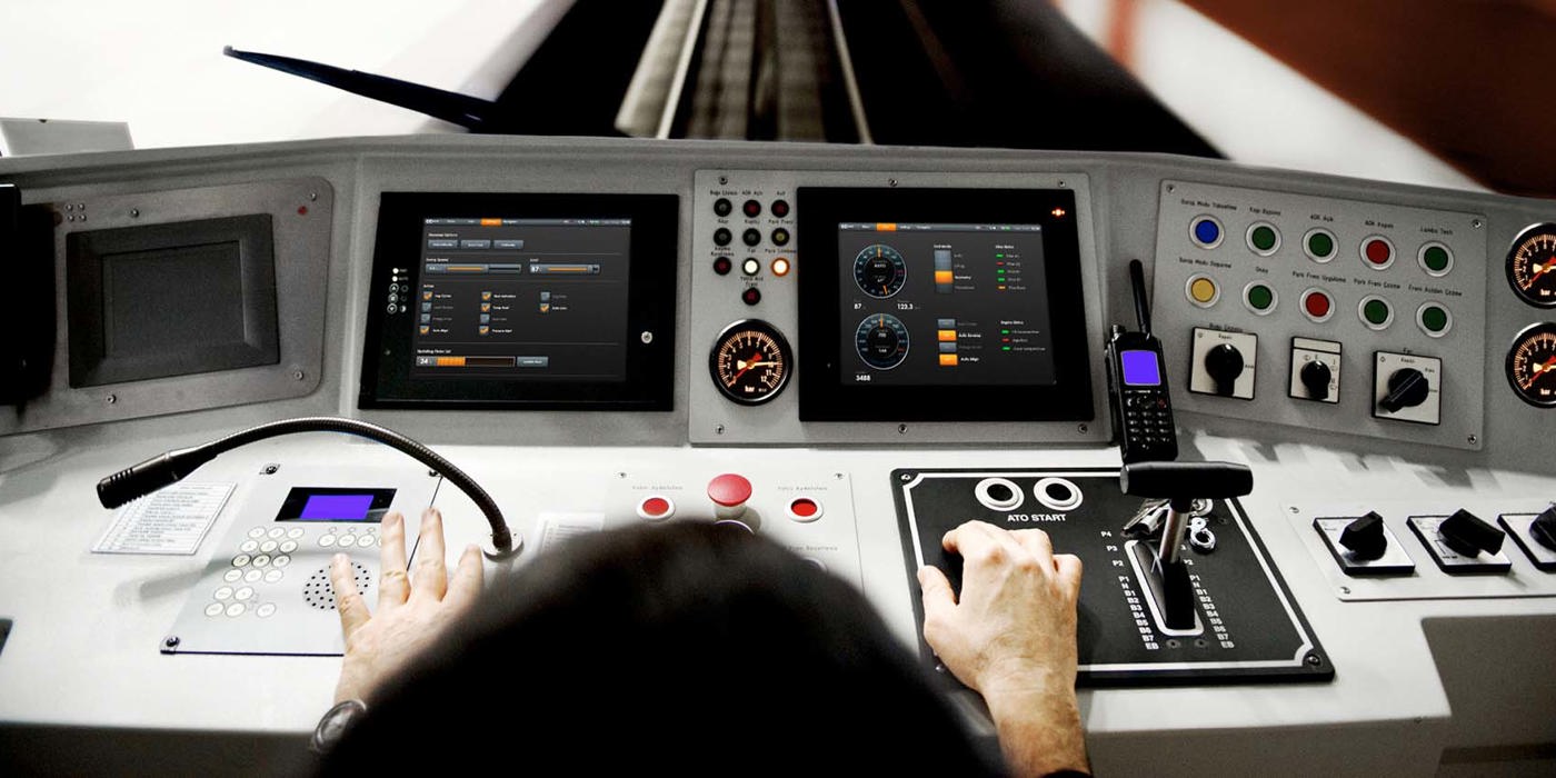 Rail vehicle cabin, operator handeling the HMI system.